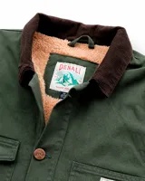 Campera estilo workwear de canvas resistente color verde oscuro. Cuenta con interior forrado en corderito sherpa, cuello de pana en tono marrón, cierre frontal con botones metálicos color cobre, cuatro bolsillos frontales y un bolsillo interior.