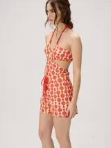 Top halter estampado en tonos rojo y beige, con tirantes finos ajustables al cuello y detalle de cuentas.