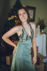 Vestido largo con estampado tie-dye en tonos violeta y fucsia, escote en V con detalles bordados dorados, cut-outs laterales bajo el busto y tirantes finos que se cruzan y atan en la espalda.