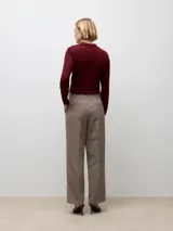 Pantalón sastrero de tiro medio con cierre de gancho y cremallera, bolsillos laterales y un fit relajado. Presenta un estampado de cuadros en tonos marrones y negros.