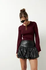 Minifalda negra de cuero sintético con cintura alta y corte globo.