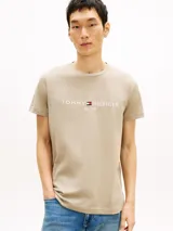 Remera Tommy Hilfiger de algodón color beige, de corte clásico con cuello redondo y manga corta. Presenta el logo de la marca bordado en el pecho junto con la inscripción "Est. 1985".