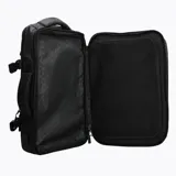 Mochila Merrell expandible de diseño técnico, color negro, con capacidad ajustable de 26 a 38 litros. Presenta múltiples compartimentos con cierres, correas de compresión laterales y asa lateral reforzada para uso versátil.