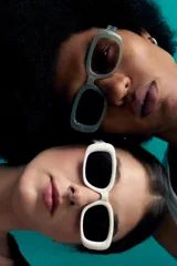 Lentes de sol con marco rectangular ancho de color verde menta translúcido. Poseen cristales de policarbonato con protección UV y un diseño envolvente de estilo retro.