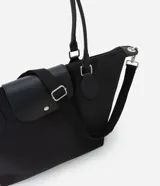 Bolso tipo shopper grande de poliéster color negro, con asas de hombro y solapa frontal con broche. Incluye correa transversal desmontable.