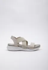 Sandalia color beige con tiras cruzadas en el empeine y tira simple. Tira de ajuste en el tobillo. Plataforma de 3 cm de alto.