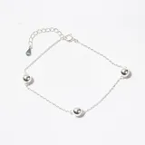 Pulsera de cadena fina de plata con tres esferas lisas distribuidas a lo largo de la pieza y cierre de mosquetón con cadena de alargue.