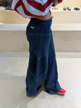 Jean de tiro medio estilo wide leg, confeccionado en denim azul oscuro, con recortes frontales y pespuntes a contratono en color ocre.