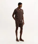 Bermuda masculina de corte recto confeccionada en tejido jacquard con textura y estampado de rayas verticales en tonos marrones. Cuenta con cintura elástica con cordón ajustable y bolsillos laterales.