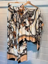 Blusa de satén con estampado de cadenas y hojas en tonos blanco, marrón y negro. Tiene corte amplio, mangas cortas y cuello redondo. Se ajusta a la cintura con un cinturón elástico negro con hebilla dorada.