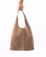 Cartera tipo hobo de cuero color bordó, con diseño de tachas metálicas plateadas dispuestas en una línea vertical central.