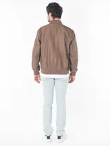 Campera bomber marrón de poliéster, con cierre frontal, puños y dobladillo acanalados, bolsillos laterales con cierre y logo CK bordado en el pecho.