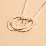 Collar con dije compuesto por tres aros entrelazados de plata 925, con cadena de eslabones tipo veneciana.