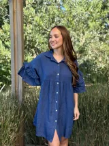 Vestido camisero blanco de lino italiano, con cuello camisero, cierre frontal con botones, mangas cortas con doble volado y bolsillos laterales.