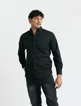Camisa de manga larga color verde oscuro, con cuello button-down, cierre frontal de botones y bolsillo en el pecho.