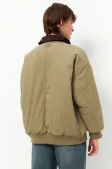 Campera negra tipo barn jacket, de corte oversized, con bolsillos laterales, puños y cuello de pana marrón. Interior capitoneado.