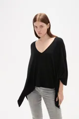 Poncho negro de tejido de punto con escote en V, diseño asimétrico y corte holgado.