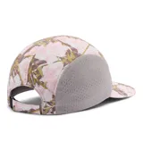 Gorro tipo gorra Columbia modelo Wingmark Cap, con paneles laterales de malla gris y diseño estampado camuflado en tonos rosados y blancos en el frente y la visera. Cuenta con logo bordado de la marca.