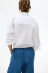 Pantalón tobillero de corte holgado en denim de algodón rígido, con cintura elástica con cordón de ajuste, bolsillos laterales discretos y piernas globo con elástico en los tobillos.
