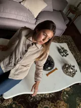 Blazer de jean color beige con cuello, solapa y cuatro botones en el frente. Tiene volados de encaje negro en cuello y delantero, mangas largas con pliegues y bolsillo plaqué.