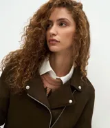 Campera estilo biker de gamuza sintética color verde militar, con cierre frontal asimétrico, cuello con solapas y botones de presión metálicos.