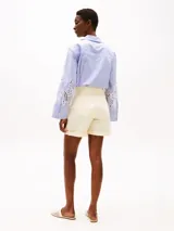 Pantalón corto color crema, de corte amplio, con dos bolsillos laterales y dos bolsillos traseros.