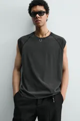 Camiseta tank gris con efecto lavado, de corte relajado, cuello redondo y manga raglán sisa.