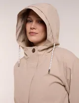 Gabardina estilo parka impermeable de color beige, con capucha fija con cordón ajustable, cierre frontal oculto con broches y bolsillos laterales.