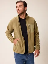 Campera de polar color verde militar, con cierre frontal completo, cuello alto y bolsillo en el pecho con cierre y detalle en tela técnica.