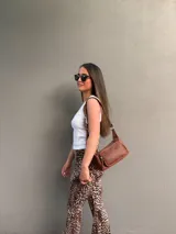 Cartera bandolera de cuero color marrón, con correa ajustable y bolsillo externo con cierre.