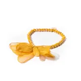 Pulsera elástica de mostacillas facetadas color amarillo mostaza, con un dije circular dorado y un lazo de organza amarillo mostaza.