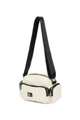 Bandolera de diseño funcional en color blanco, con múltiples compartimentos con cierre, bolsillos laterales y correa ajustable. Incluye una etiqueta frontal con la frase 'Not just a bag'.