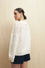 Sweater blanco de tejido de punto calado con escote redondo y mangas anchas.