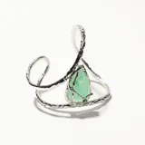 Brazalete plateado con diseño irregular y piedra sintética verde en forma de lágrima.