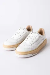 Championes urbanos Urban Haus modelo Alvaro, de cuero blanco con suela de plataforma color caramelo. Presentan cordones al tono y logo de la marca grabado en el lateral y la lengüeta.