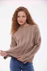 Sweater de punto trenzado color beige, con cuello alto y mangas largas.