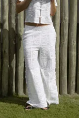 Pantalón blanco con estampado floral, de corte palazzo y cintura alta.