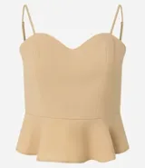 Blusa estilo corset color beige claro, con escote corazón y breteles finos. Presenta un corte ajustado en el torso y un volado peplum en el bajo.