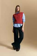 Chaleco tejido color crema con diseño de rombos calados, cuello redondo y sisas.