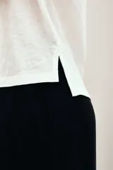 Remera blanca de algodón con cuello en V, mangas cortas y calce relajado.