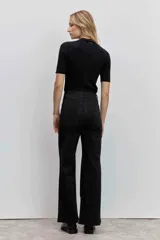 Blusa de punto acanalado en color negro, con cuello alto y mangas cortas ajustadas.