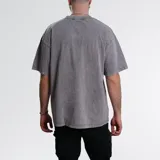 Remera gris de algodón con efecto acid wash, cuello redondo y corte holgado.