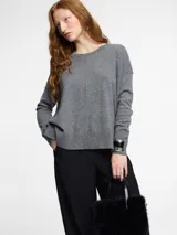Sweater gris de cashmere con silueta relajada, cuello redondo abierto y sisa caída. Presenta detalles acanalados en el ruedo y los puños, y un sutil diseño vertical en el centro delantero.