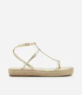 Sandalia plana tipo flatform de color dorado, con tiras finas en diseño Salomé y suela con detalle de yute trenzado.