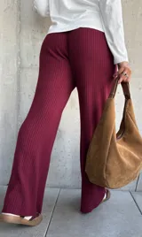 Pantalón de punto acanalado color bordó, con corte amplio y cintura elástica con cordón ajustable.