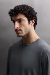 Camiseta negra de entrenamiento de corte regular fit, confeccionada en tejido técnico ligero y elástico. Cuenta con cuello redondo, mangas largas, costuras planas y logo estampado. Zara Athleticz.