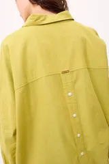 Camisa oversize a rayas verticales rosas y blancas, con cuello clásico, cierre frontal con botones y mangas largas.