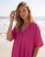Vestido estilo túnica color fucsia de lino, con escote en V, manga corta, bolsillos laterales y diseño asimétrico más largo en la parte trasera.