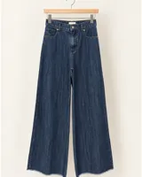 Jean wide leg de denim azul con tiro alto, bolsillos delanteros y traseros, y terminación desflecada en el ruedo.