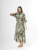 Falda midi de organdí color verde con estampado floreado, diseño cruzado con volados y corte asimétrico.